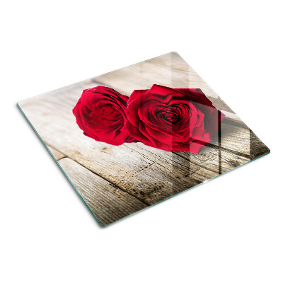 Glass kitchen board Red roses on a wooden background
