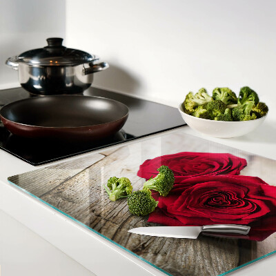 Glass kitchen board Red roses on a wooden background