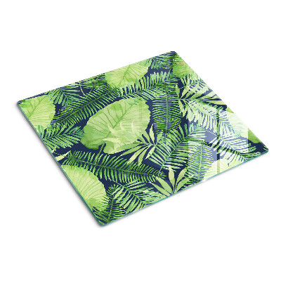 Glass chopping board Tropical leaves on a dark background