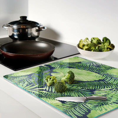 Glass chopping board Tropical leaves on a dark background