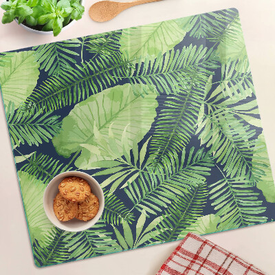 Glass chopping board Tropical leaves on a dark background