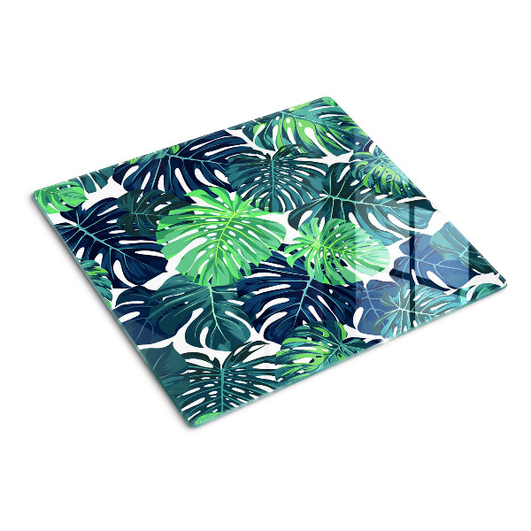 Glass kitchen board Monstera leaves on a tropical background