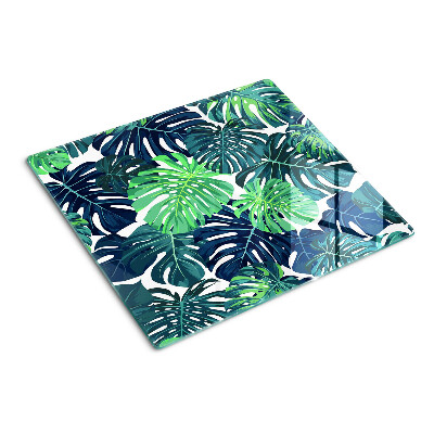 Glass kitchen board Monstera leaves on a tropical background
