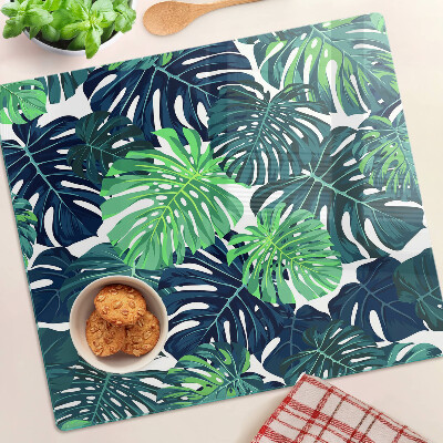 Glass kitchen board Monstera leaves on a tropical background
