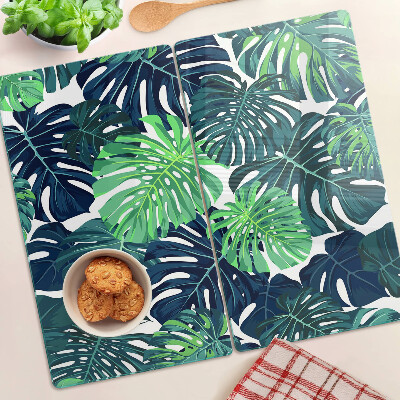 Glass kitchen board Monstera leaves on a tropical background