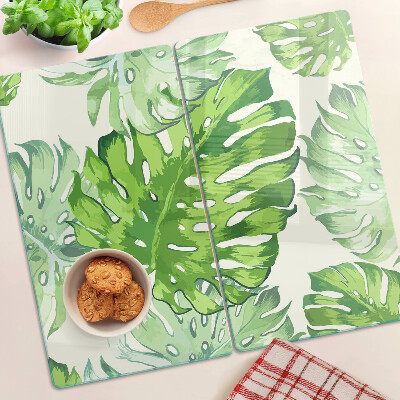 Glass kitchen board Monstera leaves on a light background