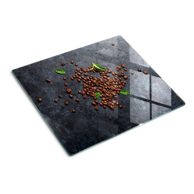 Glass chopping board Coffee beans on a stone background