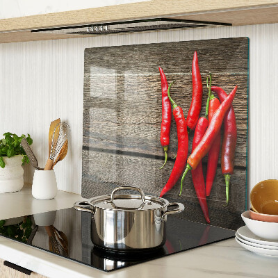 Glass chopping board Chili peppers on a wooden background