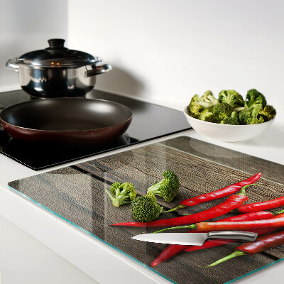 Glass chopping board Chili peppers on a wooden background