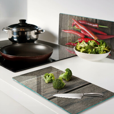 Glass chopping board Chili peppers on a wooden background