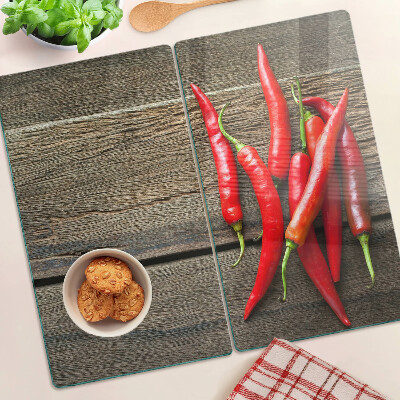 Glass chopping board Chili peppers on a wooden background