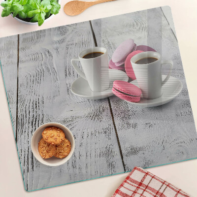 Glass chopping board Coffee and macaroons on a wooden background