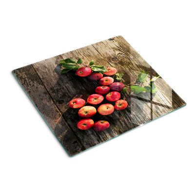 Glass chopping board Apples on a wooden background