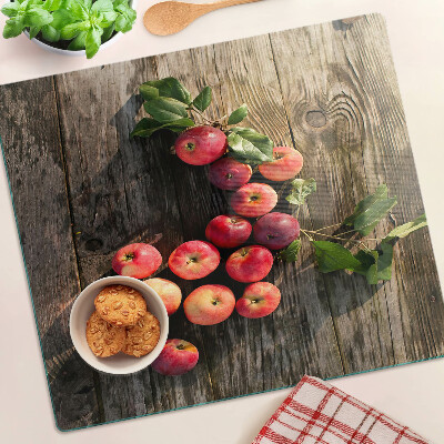 Glass chopping board Apples on a wooden background
