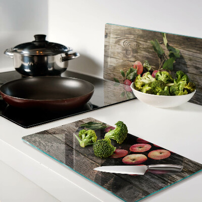 Glass chopping board Apples on a wooden background