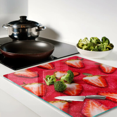 Glass chopping board Strawberries on a pink background