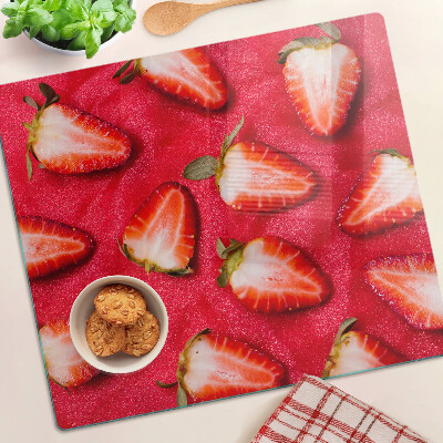 Glass chopping board Strawberries on a pink background