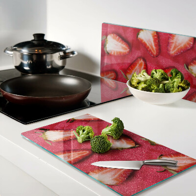 Glass chopping board Strawberries on a pink background