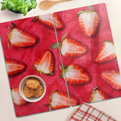 Glass chopping board Strawberries on a pink background