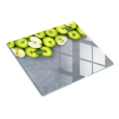 Glass chopping board Green apples on a gray surface
