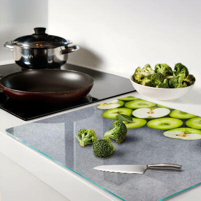 Glass chopping board Green apples on a gray surface