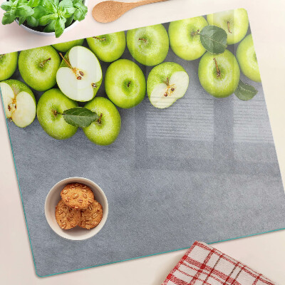 Glass chopping board Green apples on a gray surface