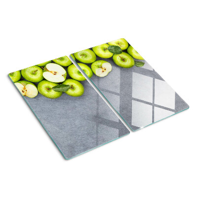 Glass chopping board Green apples on a gray surface