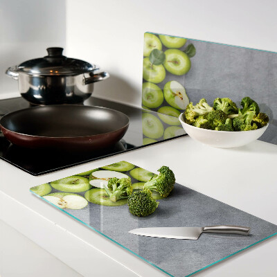 Glass chopping board Green apples on a gray surface
