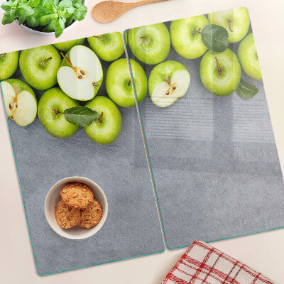 Glass chopping board Green apples on a gray surface