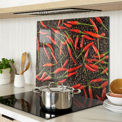 Glass chopping board Chili peppers on black pepper