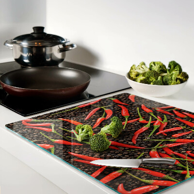 Glass chopping board Chili peppers on black pepper