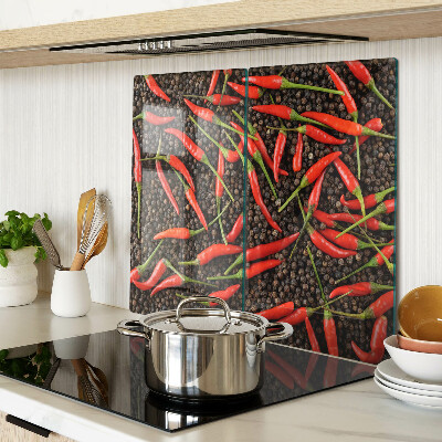 Glass chopping board Chili peppers on black pepper