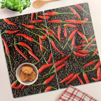 Glass chopping board Chili peppers on black pepper