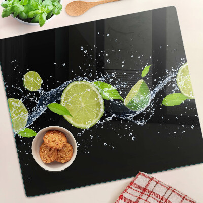 Glass chopping board Lemons in water with mint leaves