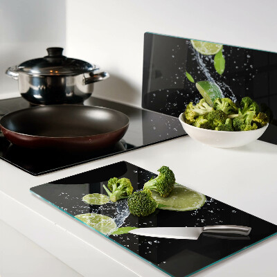Glass chopping board Lemons in water with mint leaves
