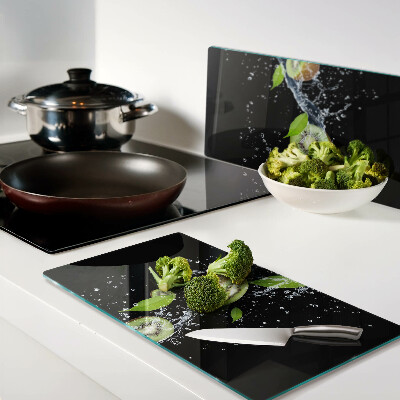 Glass chopping board Kiwi in water with leaves