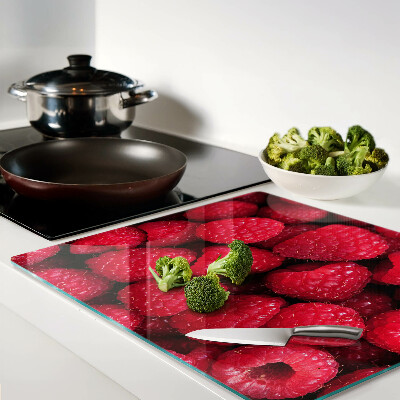 Glass chopping board Raspberries on the background