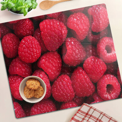 Glass chopping board Raspberries on the background