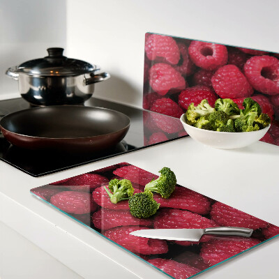 Glass chopping board Raspberries on the background
