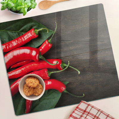 Glass kitchen board Chili peppers on a wooden background