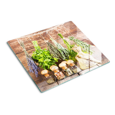 Glass chopping board Herbs and spices on a wood background