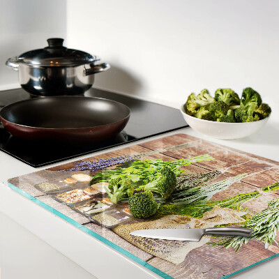 Glass chopping board Herbs and spices on a wood background