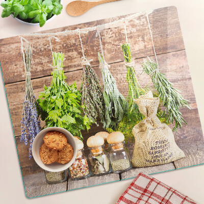 Glass chopping board Herbs and spices on a wood background