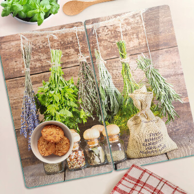 Glass chopping board Herbs and spices on a wood background