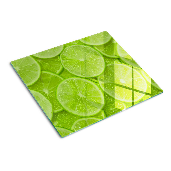 Glass chopping board Lime slices on a green background
