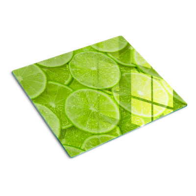 Glass chopping board Lime slices on a green background
