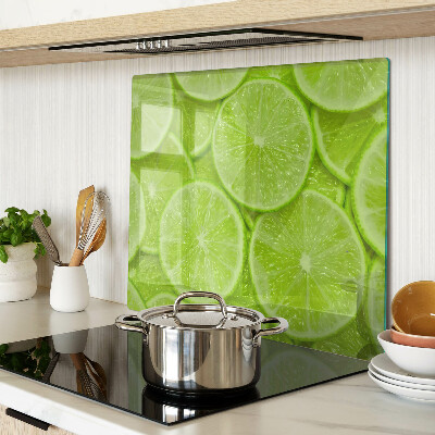Glass chopping board Lime slices on a green background