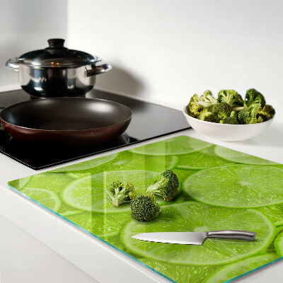 Glass chopping board Lime slices on a green background