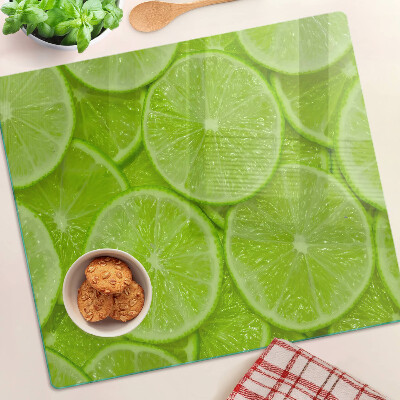 Glass chopping board Lime slices on a green background