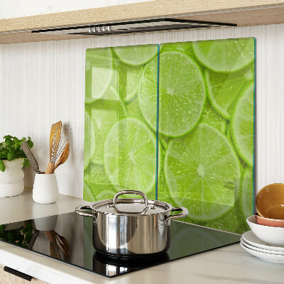 Glass chopping board Lime slices on a green background
